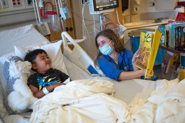 Amanda Penichet reads to a UCLA Mattel Children's Unit patient at UCLA Santa Monica Medical Center.