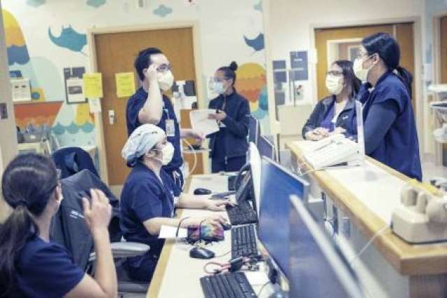 Nurses wearing masks and speaking to each other in the hospital