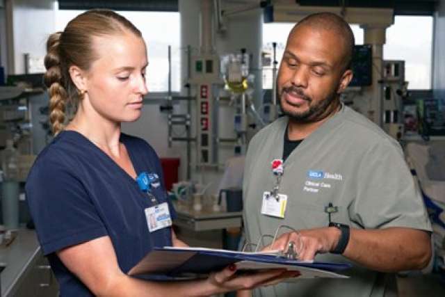 Healthcare professionals discussing a patient's chart in a hospital setting.