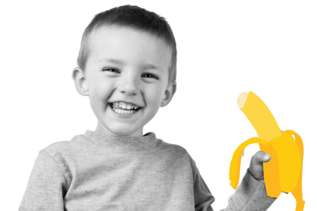 A kid smiling in black and white holding an illustrated yellow banana.
