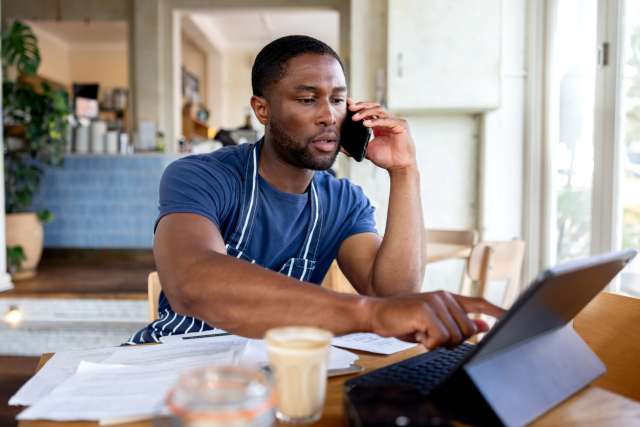 Gentleman on a phone call while using his laptop