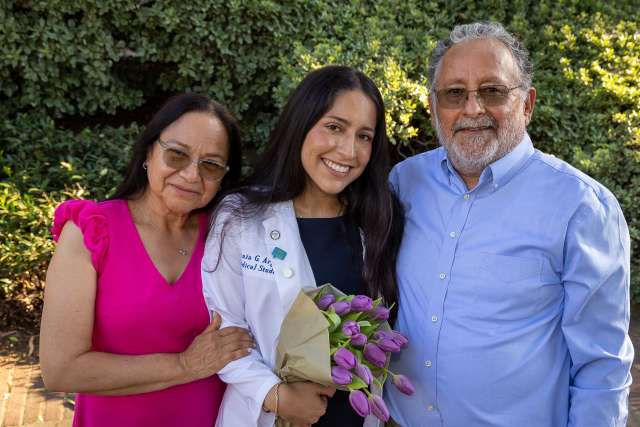 Urania Argueta celebrates the white coat ceremony with her parents, Rosa Raya and Juan Argueta. (Photo by Reed Hutchinson)