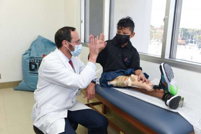 Doctor Anthony Scaduto high fiving 10-year-old Efrain Ordoñez Jr