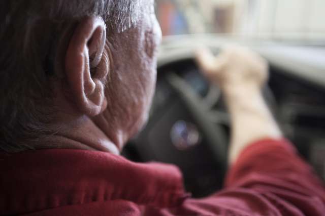 Person wearing hearing aid while driving