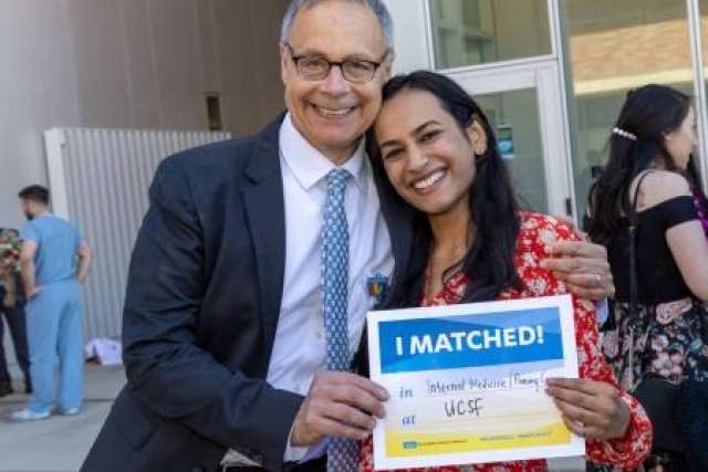  Dr. Lee Miller and Aloukika Shah smile, holding a sign that reads "I MATCHED!" with the UCLA Health and UCSF logos visible.