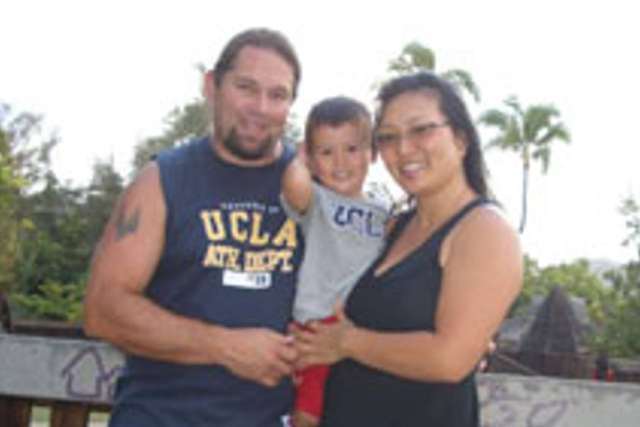 Jerry and Amy with Timmy outdoors near palm trees