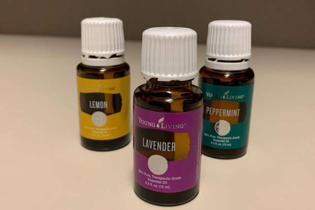 Three essential oil bottles with a purple Lavender bottle centered