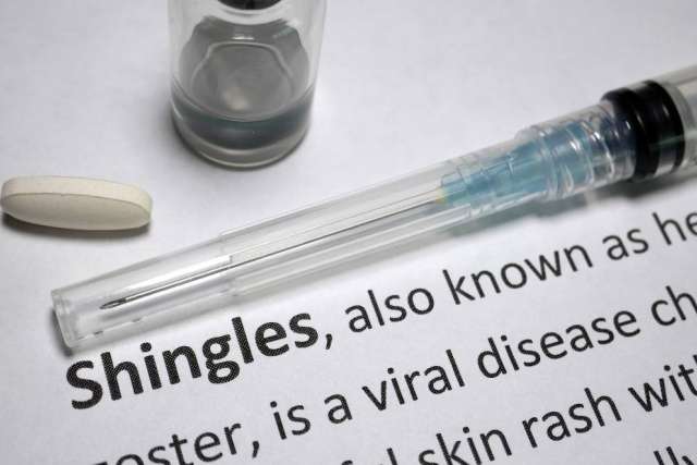 Syringe and pill beside a document titled 'Shingles'.