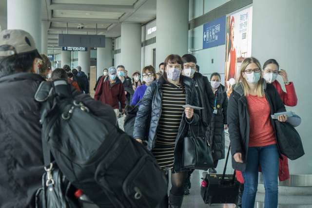 Travelers wearing face masks walk through Beijing Capital International Airport during the early COVID-19 outbreak in January 2020.