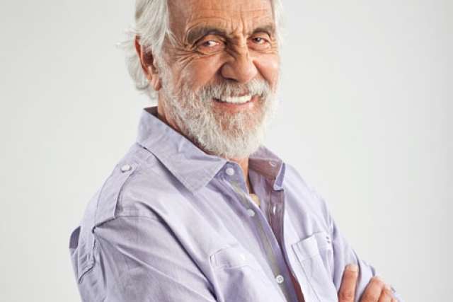 Tommy Chung smiling with white beard and crossed arms