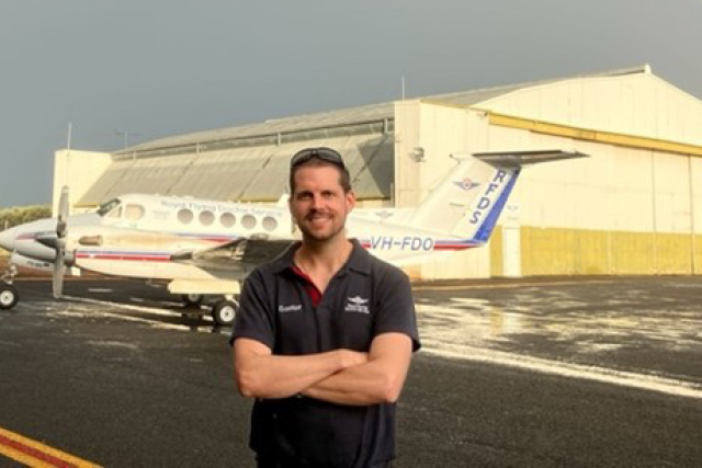 Dr. Matt Desmond in front of a medical transport airplane.