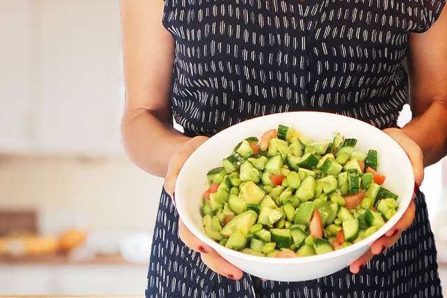 Eve's Cave Salad - Holding a Bowl in the Kitchen