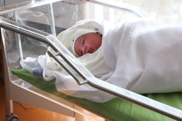 Newborn swaddled in hospital bassinet