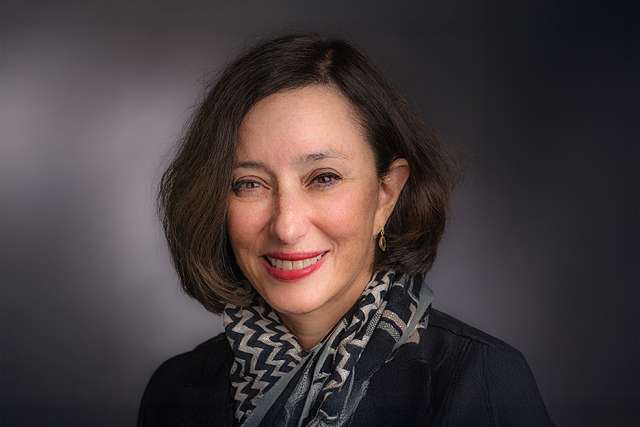 Dr. Judy Garber, smiling headshot with dark blazer and patterned scarf.