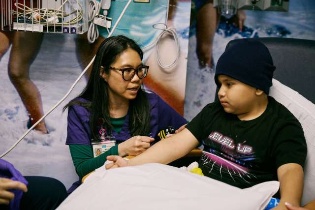 A Child Life Specialist cares for a young boy.