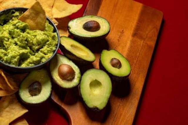 Halved avocados and guacamole with tortilla chips