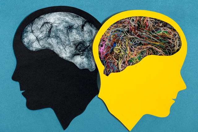 In an illustration, a brain is shown in two versions of the same head. In one, the brain is vibrant and colorful, in the other it is gloomy and grey. 