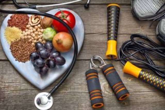 Heart-shaped plate with healthy foods beside exercise equipment, symbolizing nutrition and fitness for heart health.