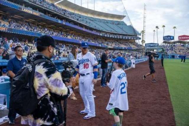 Kellen Turner interacts with fans at a baseball stadium during a game.