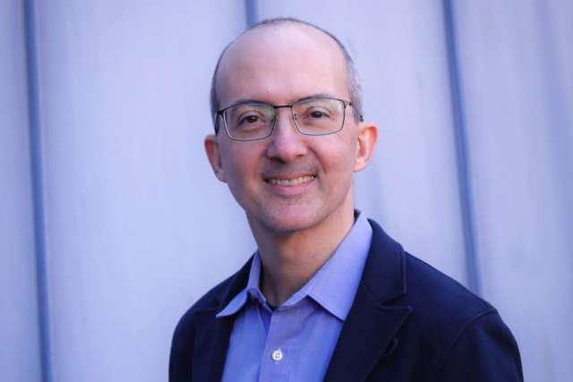 Dr. Brent Stockwell smiling headshot in blazer and glasses