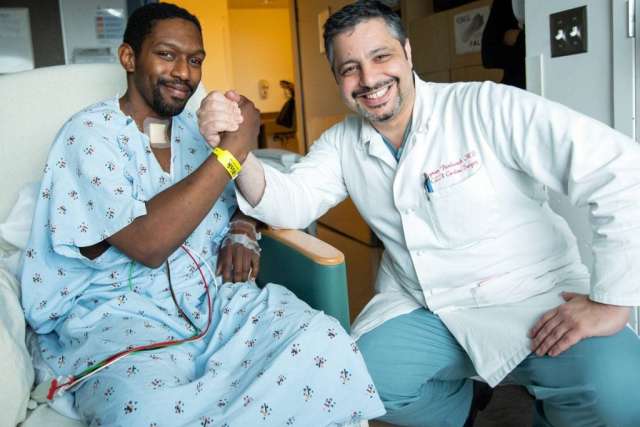 Dr, Benharash and Jonathan Cosby sitting in a hospital room smiling for the camera