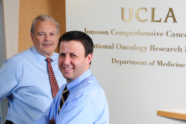 UCLA cancer researchers Dr. Dennis Slamon and Dr. Richard Finn, wearing light blue button up shirts and burgundy ties.