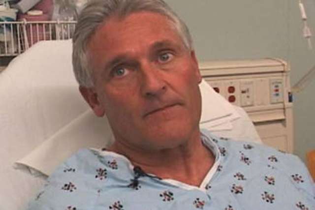 Blyden Loutensock in hospital gown on bed looking up