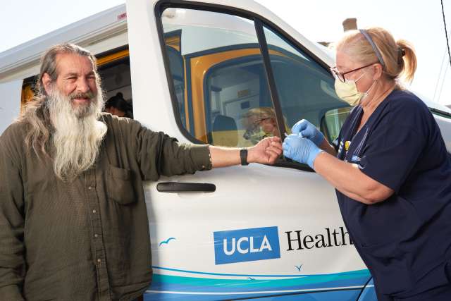 Man checked by nurse next to care van