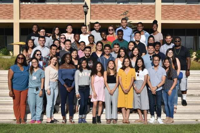 UCLA PREP alumni pose together outside on steps in front of a brick building.