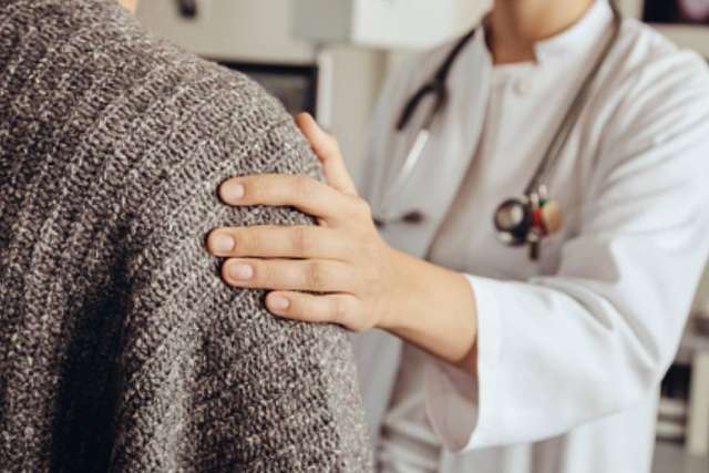 Doctor placing hand on patient's shoulder