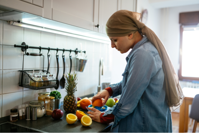 Woman in a kitchen, cutting a variety of different fruits