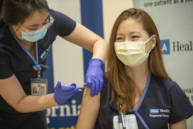 Health care workers receives COVID vaccine