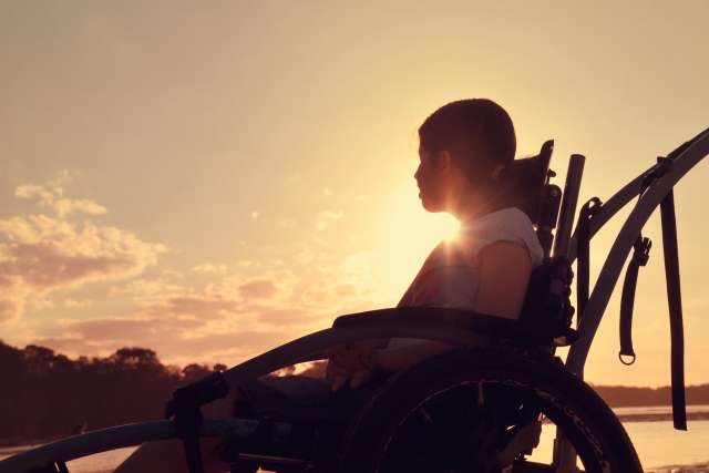 Silhouette of a woman sitting on a beach, sad and in distress