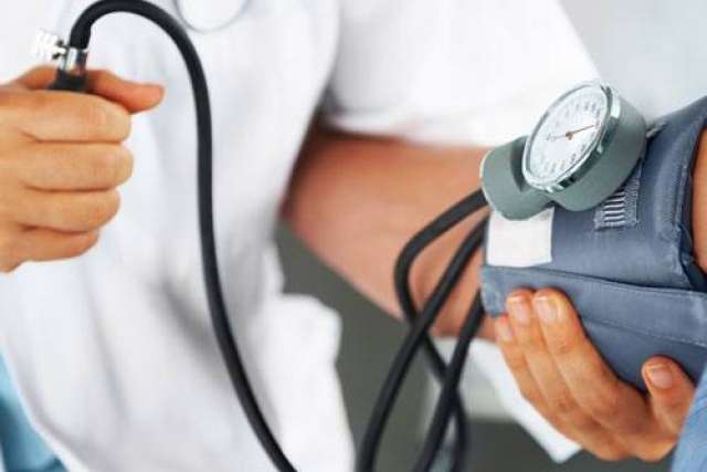 A healthcare professional measuring blood pressure on a patient's arm.