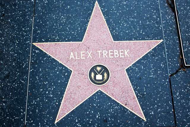 A close-up of Alex Trebek's pink star on the Hollywood Walk of Fame, featuring a television icon in the center.