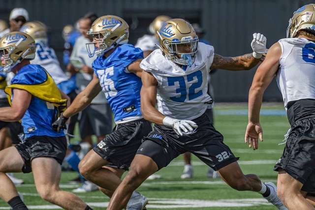 UCLA Football players in shells sprinting in practice