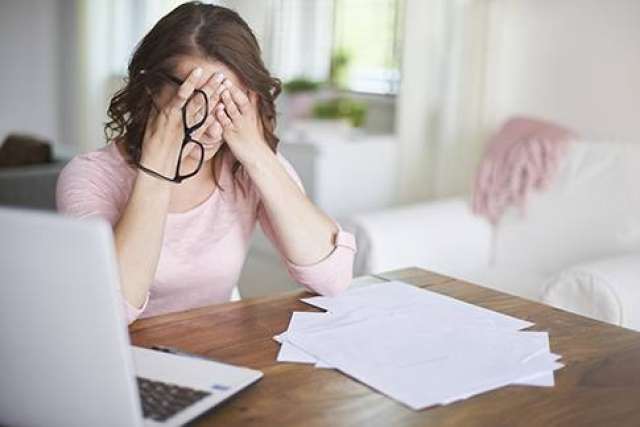 Woman covering her face as a sign of stress