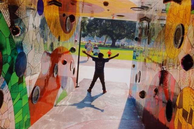 a child doing a jumping jack in a playground tunnel