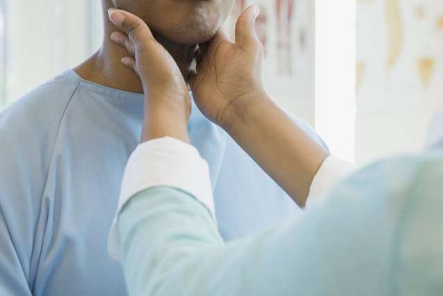 Doctor checking a patient's throat using their hands
