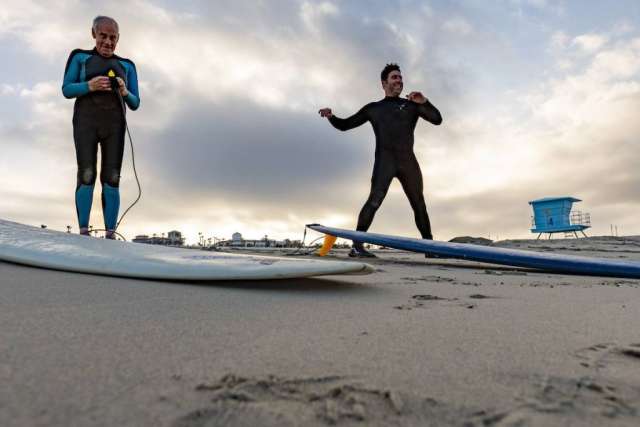 Dr. Sassoon and Robert Lombard preparing to go into the ocean with their surfboards