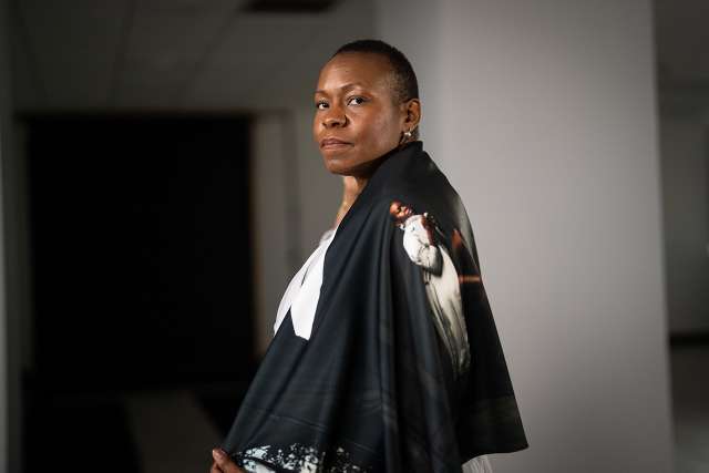 Melissa Watkins in a stylish black shawl with a graphic design, posed in an indoor setting.