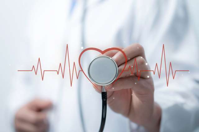 Medical worker holding stethoscope pointing heart wave Red line wave of heart beat. 