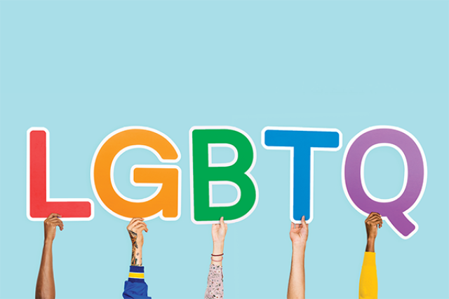 Hands holding up letters LGBTQ+