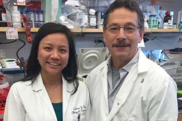 Donald Kohn and Caroline Kuo in lab coats, standing in a lab with research equipment.