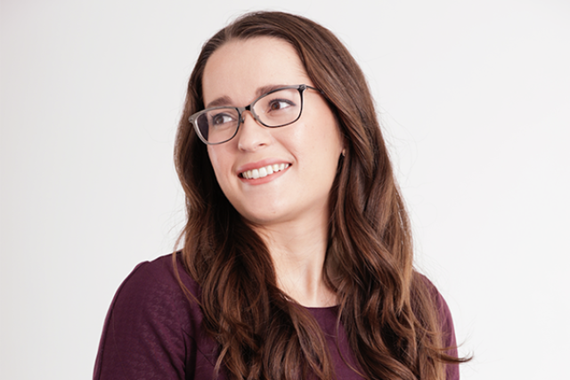 Kathryn O'Neill, a policy analyst with the Williams Institute at UCLA, posing wearing a burgundy sweater and glasses