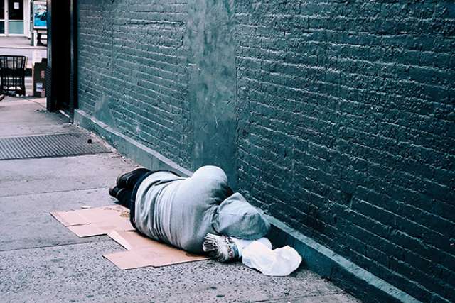 Person sleeping on sidewalk