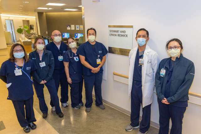 Nurses pose in front of nurses station