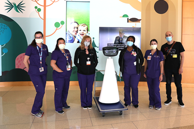 Robin the robot at the Mattel hospital with 6 members of hospital staff