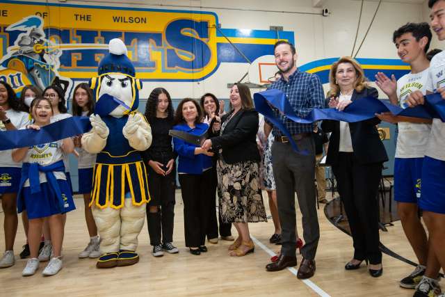 Group of student and staff cutting a ribbon