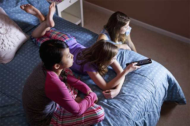 Girls on bed watching TV